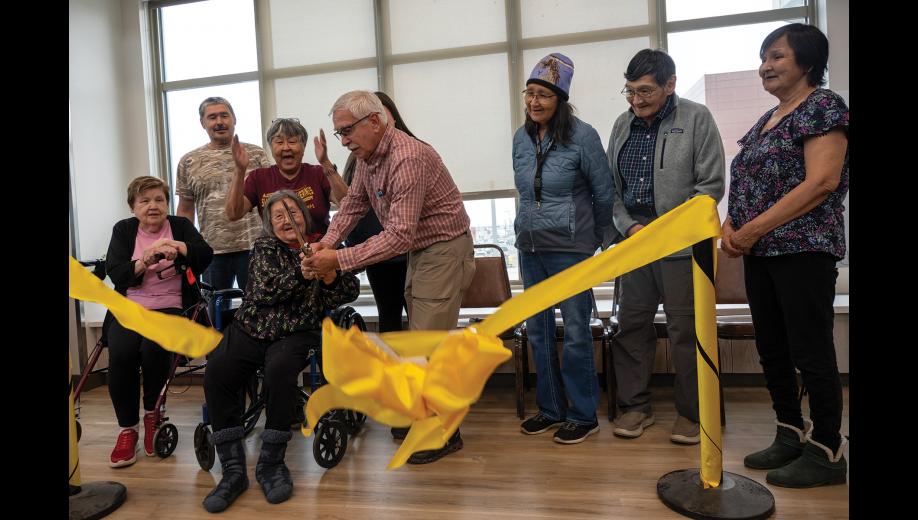RIBBON CUTTING— Norton Sound Health Corporation board members Berda Willson of Native Village of Council (seated), Charlie Brown of Chinik Eskimo Community, Matilda Hardy of Native Village of Shaktoolik, Wilma Amaktoolik of Village of Solomon, Tony Haugen board chair of Native Village of Unalakleet, Rosemary Otton of Native Village of Koyuk, Frederick Murray of Native Village of Elim, and Joanne Oxereok of Native Village of Wales celebrate as Quyanna Care Center resident Sarah Kakaruk cuts the ceremonious ribbon to QCC's expanded facility, on Thursday, September 17. Photo by Ariana Crockett O'Harra