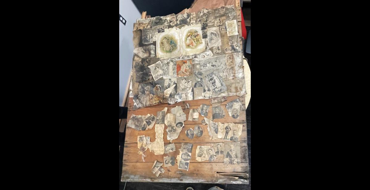 Photo by Anna Lionas BEHIND THE WALLS–This wooden slab with photos and newspaper clippings with dates ranging from the 1870s-1890s was found in the walls of the now deconstructed Seppala House. The artifacts are being preserved at the Nome Museum and will be part of the exhibit presented in the new Seppala House.