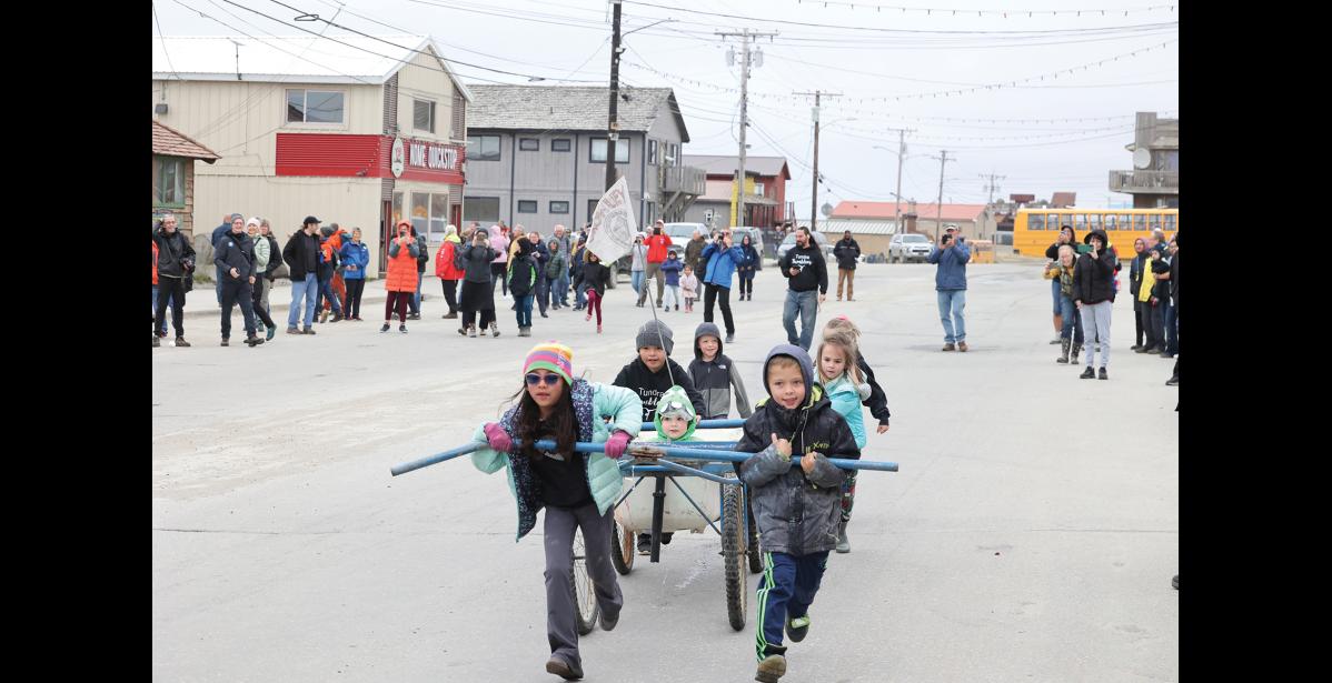 Photo by Anna Lionas TUB AND ROLL–The Running Club team makes their way down Front Street. In front: Elizabeth Phan, Douggie Coulter; Martin Bickford Paige Savok and Liliana Bickford pushing and Caleb and Ellen Stewart in the back.