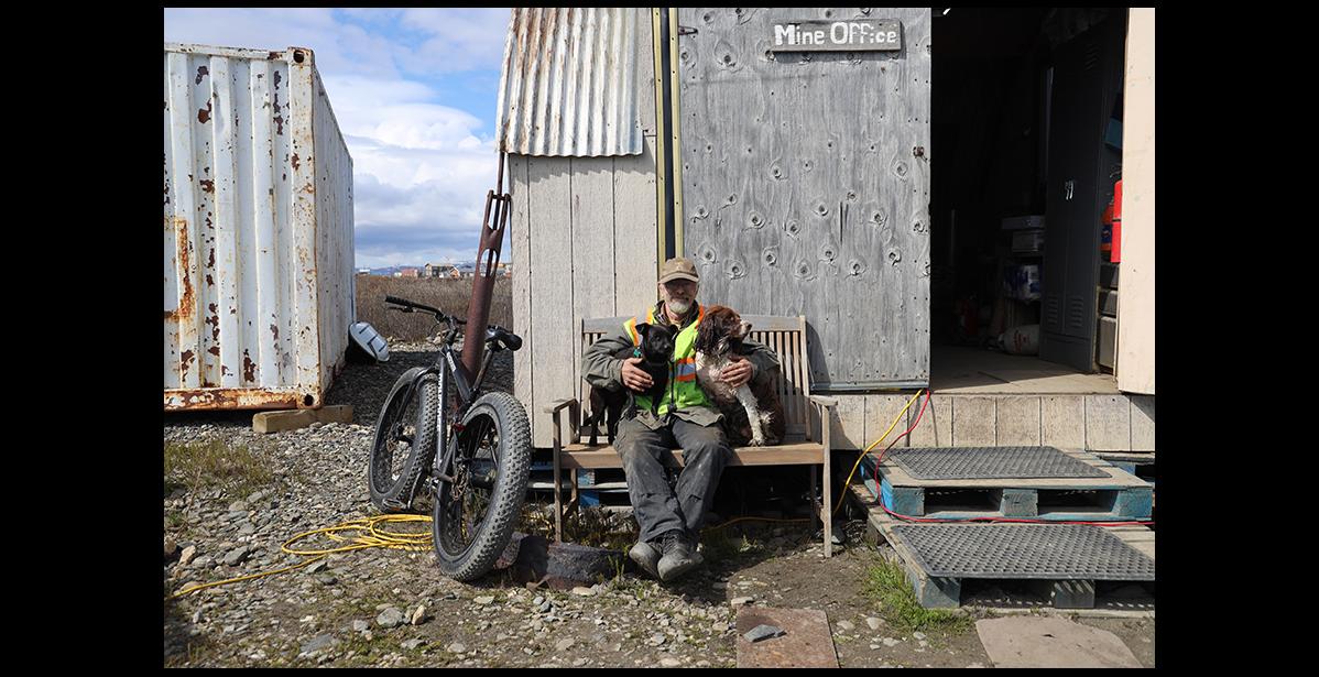 Photo by Colin Warren BOSS— Ken Hughes at his gold mine office with his “security” Dixie and Tucker.