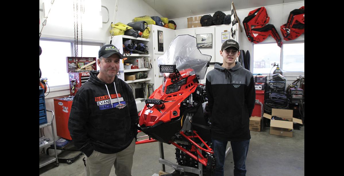 Photo by Peter Loewi GETTING READY— Dad Evan Booth and his son Steffen prep their racing machines in Nome for their first Iron Dog together as a team.