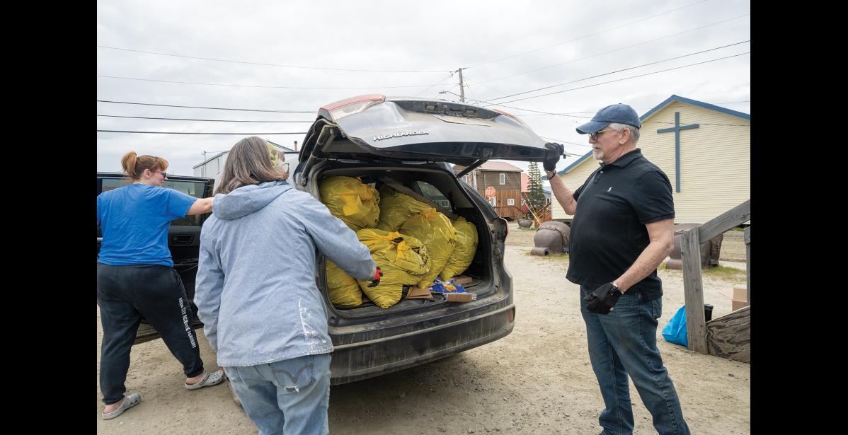 Photo by Ariana Crockett O'Harra HAULING TRASH— Rachel Ventress, left, unloads her car with the help of Patty Burchell, center, and City Manager Lee Smith in the Old St. Joe’s parking lot at the city’s spring cleanup on Saturday, June 6.