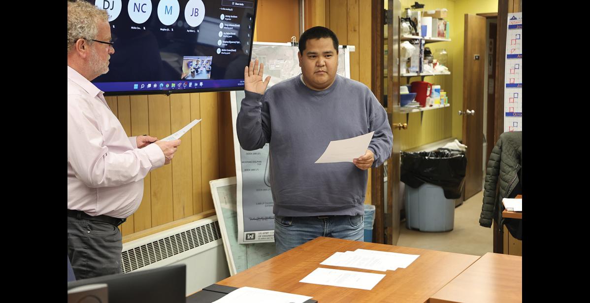 Photo by Diana Haecker OATH OF OFFICE— Nome Mayor John Handeland administers the oath of office to new Nome Common Council member Cameron Piscoya, during Monday’s regular council meeting.