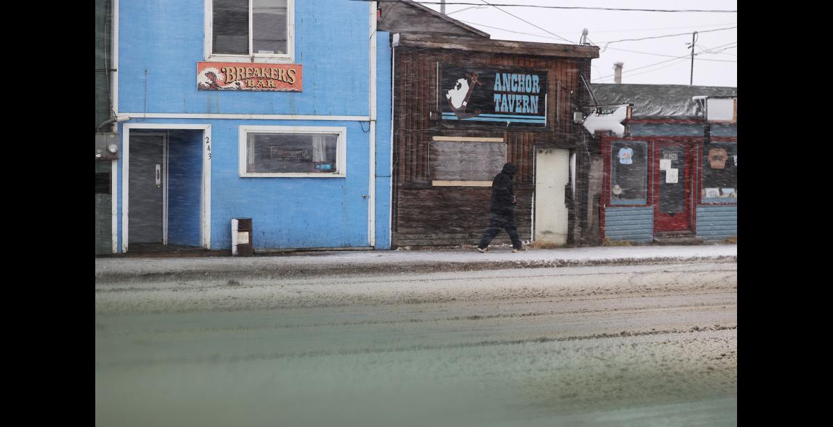 A man walks on Front Street, passing closed businesses. Photo by Diana Haecker