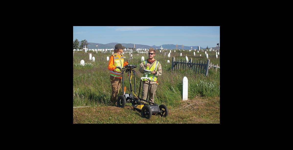 Photo by James Mason EARCHING FOR UNMARKED GRAVES— Logic Geophysics used ground penetrating radar to search for unmarked graves. Dr. Esther Babcock, left, analyzes the data. Caleb Babcock supplies the muscle.